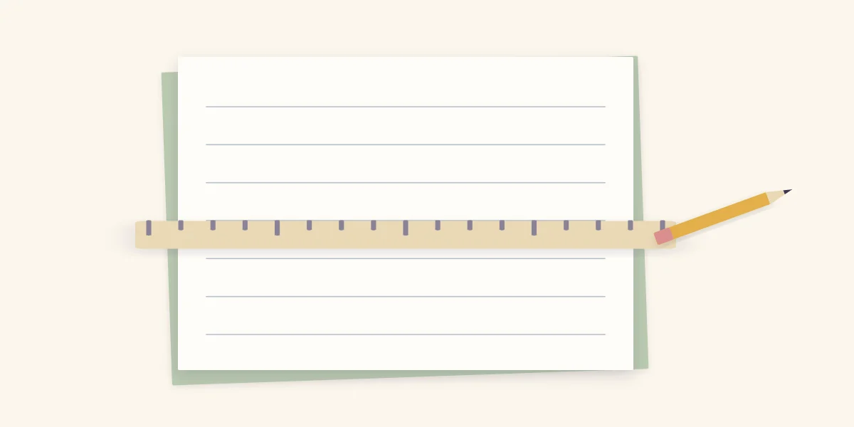 A paper block with light pencil guidelines, a ruler across it and a pencil beside it